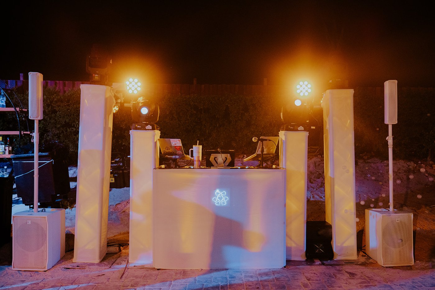 White DJ booth illuminated with warm and colored lighting